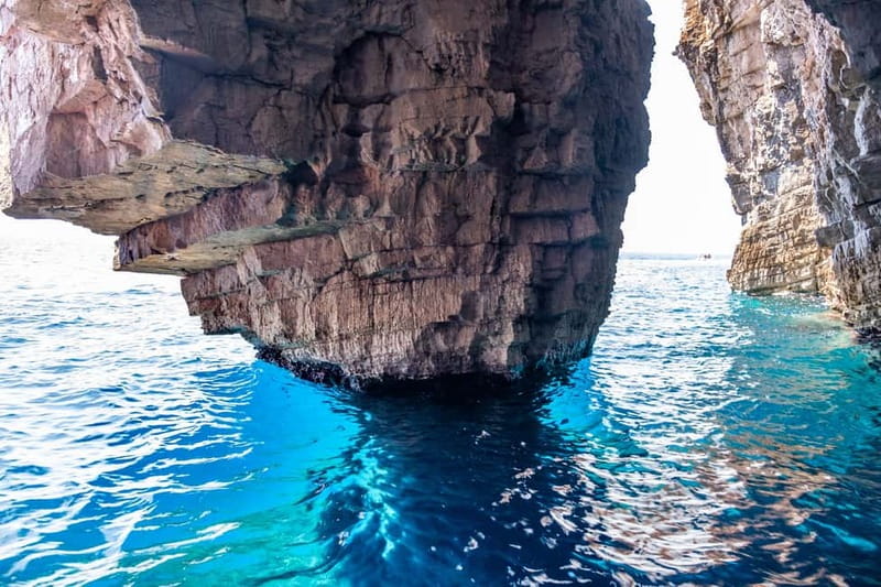 From Milna or Supetar: Magical Blue Cave Island Hopping - Entering the Blue Cave by paddle boat, with the light trick