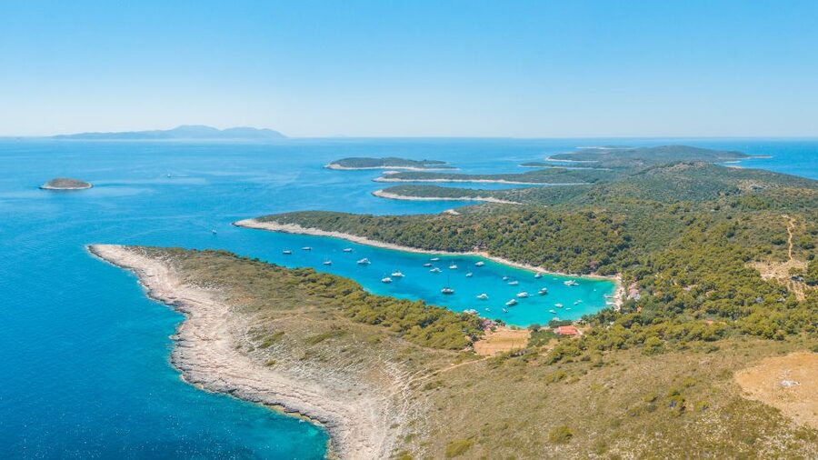 From Split: Trogir & Blue Lagoon Boat Tour with Snorkeling - Ciovo Bay pine forest views and island scenery from the water