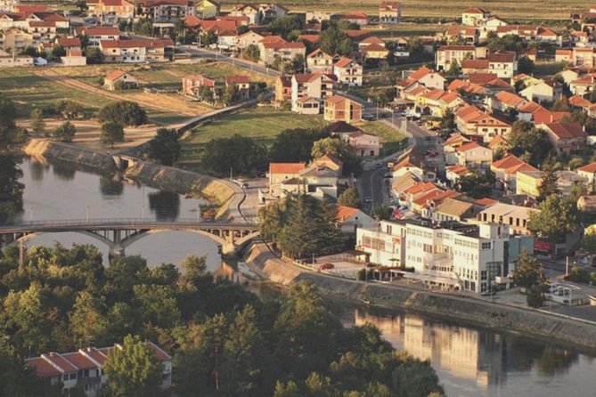 Sinj: Panoramic Flight over Peruca Lake and Dinara mountain - A small lake with a dark abyss near fields and an old village